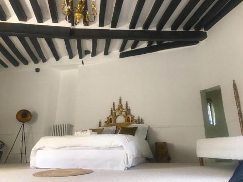 a bedroom with a white bed and a chandelier at Le Saint Leonard in Montceaux-lès-Provins