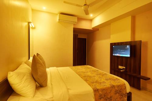 a hotel room with a bed and a tv at Hotel G-Square - Shirdi in Shirdi