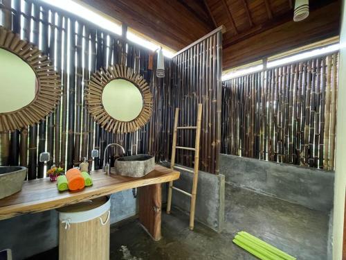 a bathroom with two sinks and two mirrors at Marind Dive Eco Resort in Waha