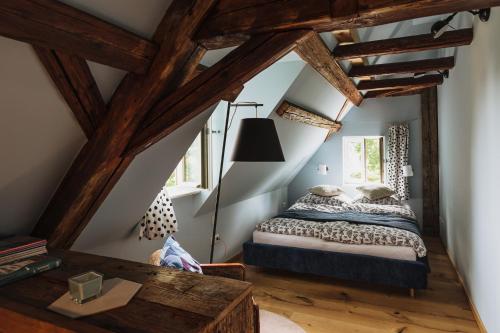 a attic bedroom with a bed and a table at Flecksches Gut in Leipzig