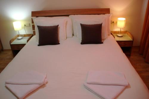 1 dormitorio con 1 cama blanca grande y 2 lámparas en Luxury one bed apartment with hydro bath in Royal Plaza, en Borovets
