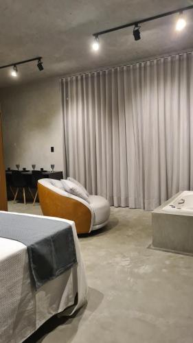 a bedroom with a bed and a tub in it at Refúgio da Mata in Morretes