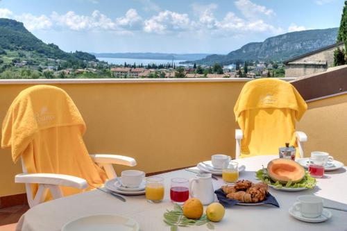a table with food and drinks on top of a balcony at Poiano Garda Resort Appartamenti in Garda