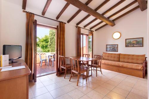 ein Wohnzimmer mit einem Tisch und einem Sofa in der Unterkunft Poiano Garda Resort Appartamenti in Garda