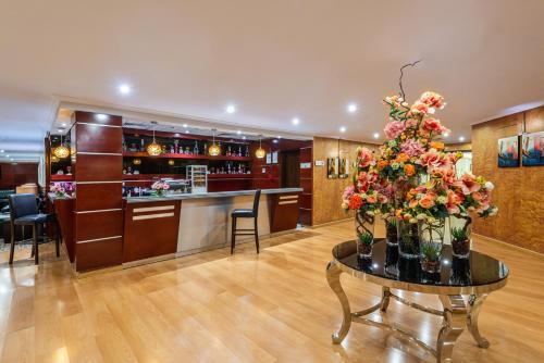 a lobby with a bar and a table with flowers at Boudl Abha in Abha