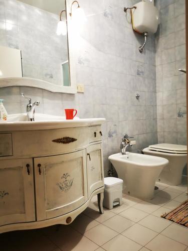 a bathroom with a sink and a toilet and a mirror at Dimora alla Villa in Ostuni