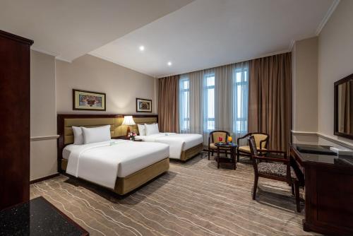 a hotel room with two beds and a desk at Boudl Abha in Abha