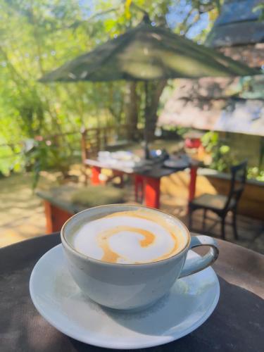 a cup of coffee sitting on a table at Moksha eco villa Ella in Ella