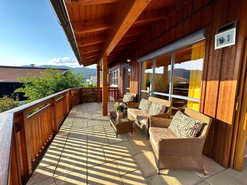 a porch with chairs and tables on a house at Ferienhaus Sonnenberg in Reith bei Seefeld