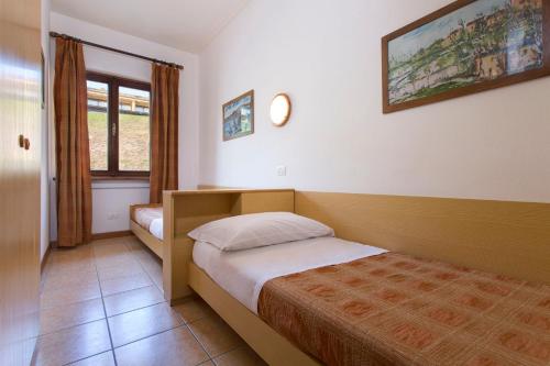 a bedroom with a bed and a clock on the wall at Poiano Garda Resort Appartamenti in Garda