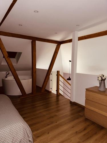 a bedroom with a bed and a wooden floor at Gîte Cosy au cœur de l'Alsace in Roggenhouse