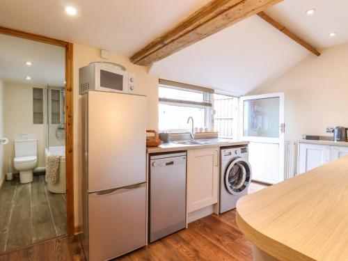 eine Küche mit einem Kühlschrank, einer Waschmaschine und einem Trockner in der Unterkunft Tembo's Rest in Sandwich
