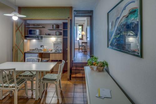 a kitchen and dining room with a table and chairs at Poiano Garda Resort Appartamenti in Garda