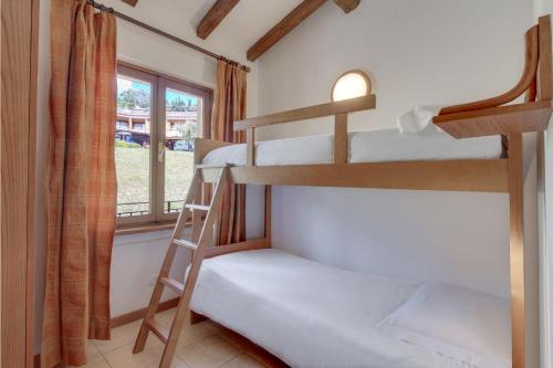 a bunk bed room with two bunk beds and a window at Poiano Garda Resort Appartamenti in Garda