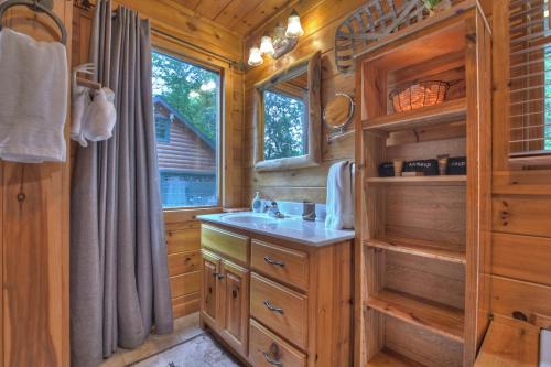 a bathroom with a sink in a wooden cabin at CaBEARnet Creek Cabin - hot tub, pet friendly, fire pit, outdoor fireplace in Morganton