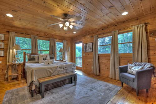 a bedroom in a log cabin with a bed and a chair at CaBEARnet Creek Cabin - hot tub, pet friendly, fire pit, outdoor fireplace in Morganton