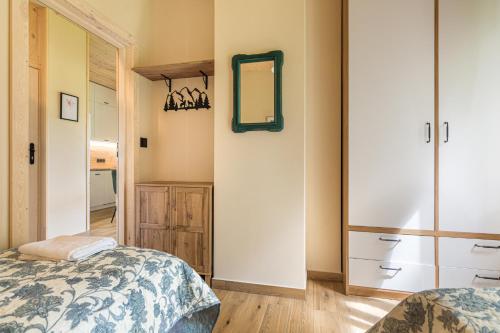 a bedroom with a bed and a mirror on the wall at Rentynówka in Gietrzwałd