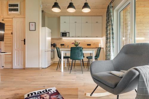 a kitchen and living room with a table and chairs at Rentynówka in Gietrzwałd