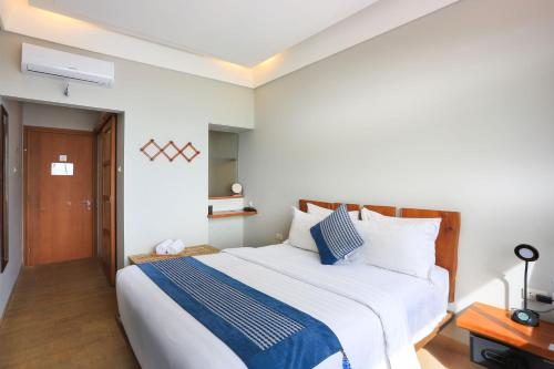 a bedroom with a large bed with blue and white pillows at Damar Toba in Balige