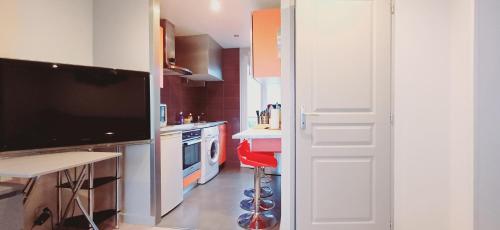 cocina con TV grande y taburete rojo en Bellerive, pieds dans l'eau lac & montagnes, en Publier