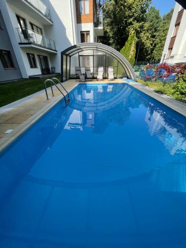 a swimming pool with blue water in a house at Klimatyzowany apartament z basenem i garażem Willa 4 Pory Roku in Jastrzębia Góra