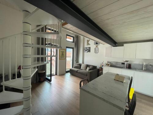 uma cozinha e sala de estar com uma escada em espiral em Casa P em Malgrate
