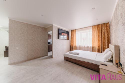 ein Schlafzimmer mit einem Bett und einem großen Fenster in der Unterkunft Однокомнатная квартира в центре Лото in Petropawlowsk