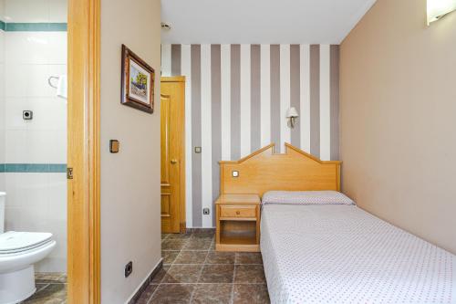 a bedroom with a bed and a sink and a toilet at Hostal Don Juan in Meco