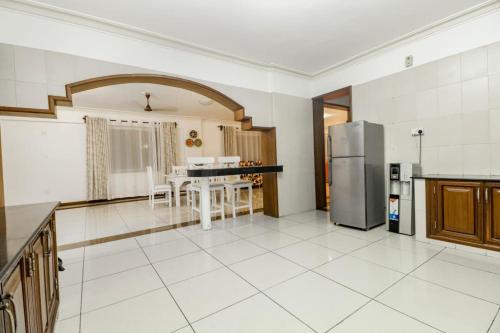 a large kitchen with a table and a refrigerator at Lealy home sweet home in Mombasa