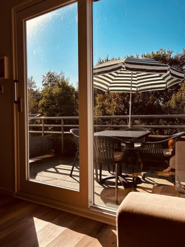 a view of a patio with a table and an umbrella at Westend Amelander Kaap 85 in Hollum
