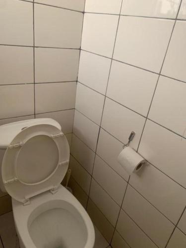 a bathroom with a toilet and a roll of toilet paper at Lux Suites Rio Vista Executive Studio Apartments in Makandara
