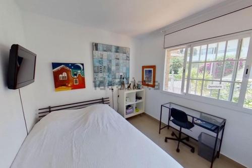 a bedroom with a bed and a desk and a window at Haidys House - Disfruta de las Vistas al mar in Castelldefels