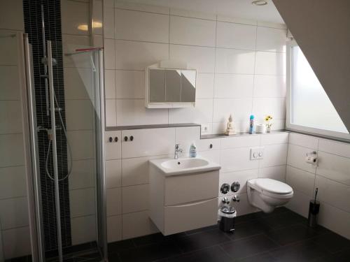 a white bathroom with a sink and a toilet at Beautiful Maisonette in Mörfelden-Walldorf in Mörfelden-Walldorf