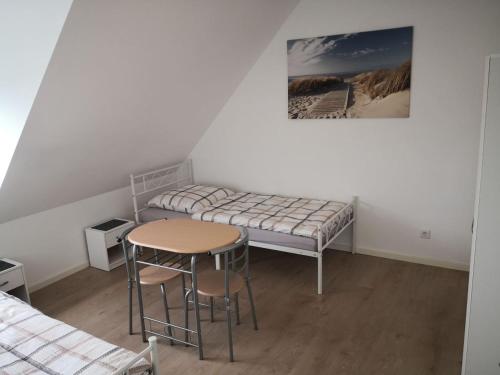 a room with a bed and a table and stool at Beautiful Maisonette in Mörfelden-Walldorf in Mörfelden-Walldorf