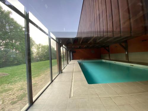 a swimming pool in a house with large windows at Les Ferreries Saillagouse in Saillagouse