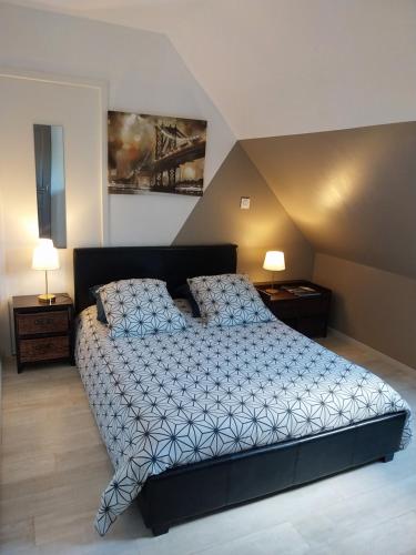 ein Schlafzimmer mit einem großen Bett und zwei Nachttischen in der Unterkunft Au fil de l'eau in Rohan