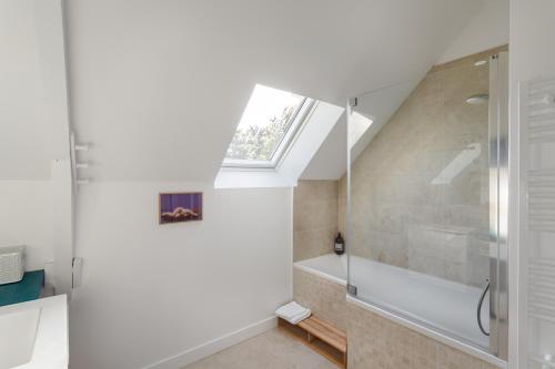 a bathroom with a shower and a window at Les Flots Bleus - Jolie maison proche de la mer in Cancale