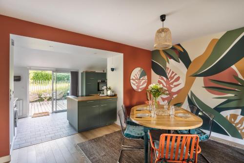 une cuisine et une salle à manger avec une table et des chaises dans l'établissement Les Flots Bleus - Jolie maison proche de la mer, à Cancale