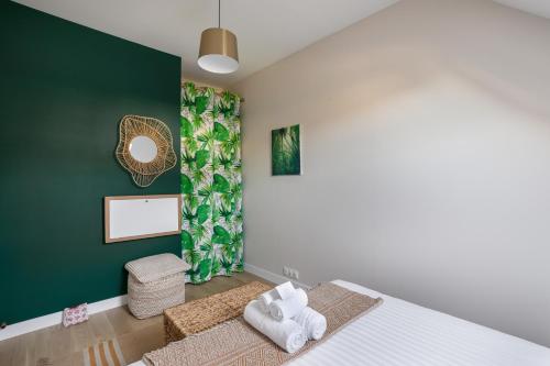 a bedroom with a bed and a green wall at Les Flots Bleus - Jolie maison proche de la mer in Cancale