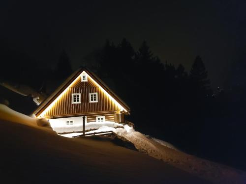 a small house in the snow at night at Kajzrovka in Rokytnice nad Jizerou