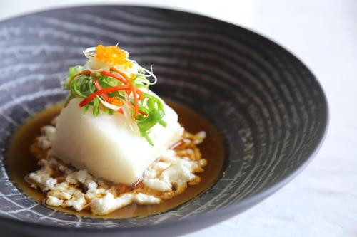 a plate of food with a piece of cheese on top at Melia Hanoi in Hanoi