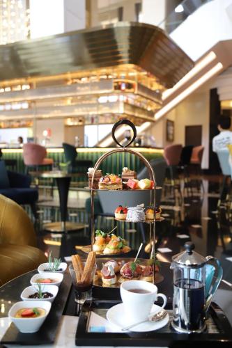 a table with plates of food and cups of coffee at Melia Hanoi in Hanoi