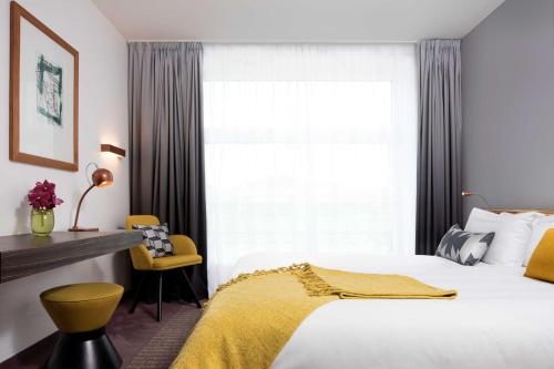a bedroom with a white bed and a window at art'otel berlin mitte, Powered by Radisson Hotels in Berlin