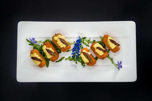 a white plate with four different types of food on it at art'otel berlin mitte, Powered by Radisson Hotels in Berlin