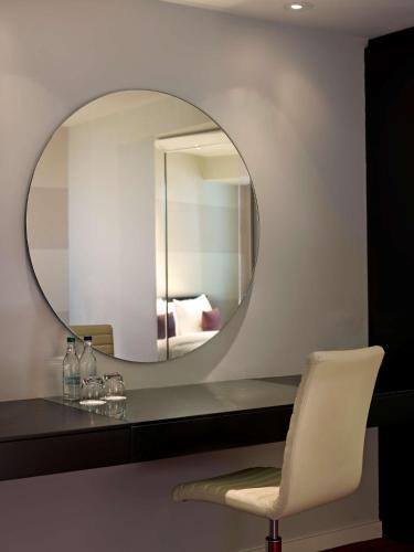 a room with a mirror and a white chair at Park Plaza Leeds in Leeds