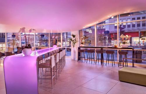 ノッティンガムにあるパーク プラザ ノッティンガムの紫色の照明と椅子が備わるバー付きのレストラン