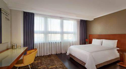 a hotel room with a bed and a desk and a window at Park Plaza Nottingham in Nottingham