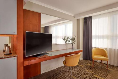 a hotel room with a flat screen tv and a chair at Park Plaza Nottingham in Nottingham