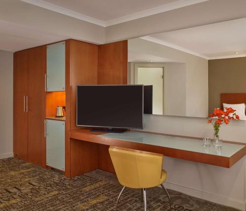a room with a desk with a television and a yellow chair at Park Plaza Nottingham in Nottingham