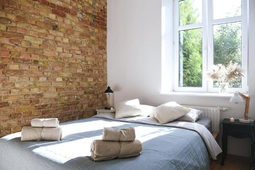 a bedroom with two beds and a brick wall at Mini Loft Janickiego in Szczecin